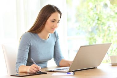 Serbest meslek sahibi bir dijital tablet ve bir dizüstü bilgisayar ile çalışma