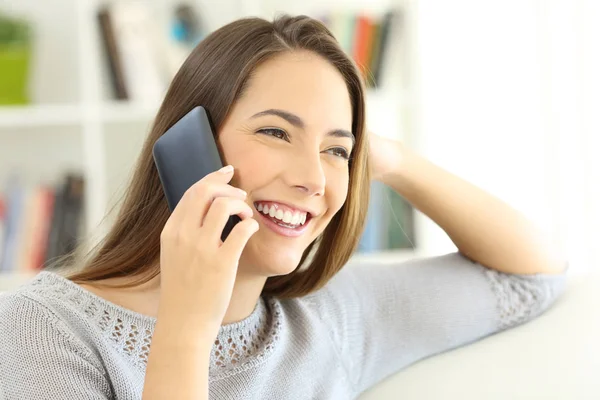 Lady talking on mobile phone seated at home — Stock Photo, Image