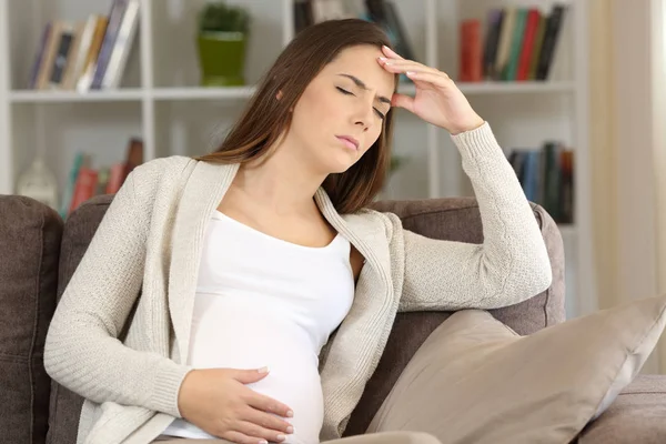 Беременная женщина страдает мигренью дома — стоковое фото