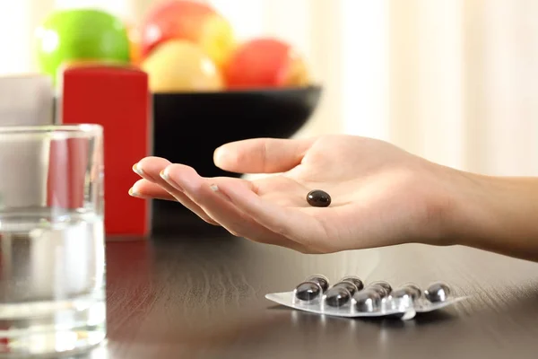 Mujer de la mano sosteniendo una píldora compleja vitamina —  Fotos de Stock