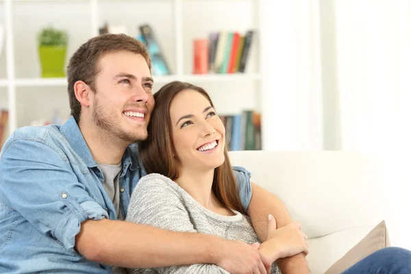 Casal feliz sonhando olhando acima em casa — Fotografia de Stock