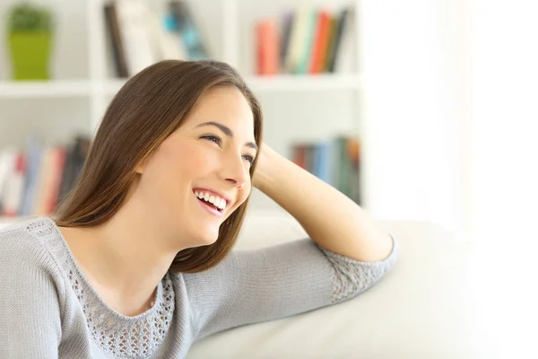 Pensive girl looking away on a couch — Stock Photo, Image