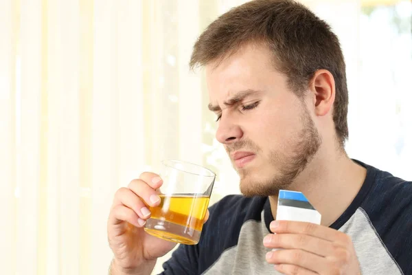 Hombre bebiendo una medicina con mal gusto —  Fotos de Stock
