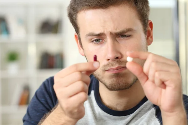 Homem se perguntando sobre pílula ou cápsula — Fotografia de Stock