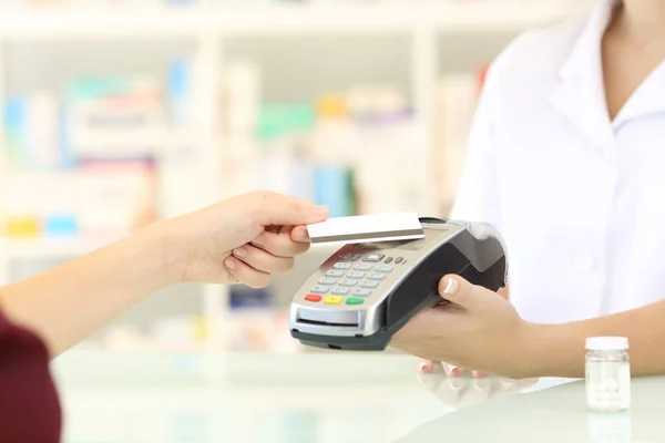 Клиент, оплачивающий кредитными картами в аптеке — стоковое фото