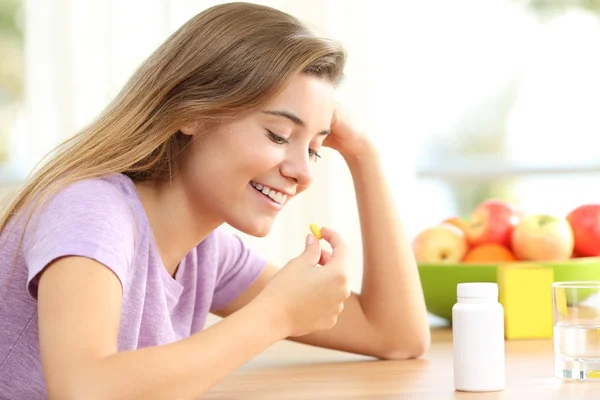 Feliz adolescente tomando uma pílula vitamínica em casa — Fotografia de Stock