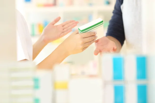 Mãos farmacêuticas vendendo medicamentos a um cliente — Fotografia de Stock