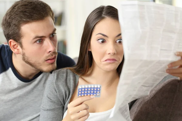 Casal suspeito lendo um folheto depois de tomar pílulas contraceptivas — Fotografia de Stock