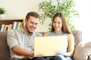 Bir dizüstü bilgisayar birlikte kanepede kullanarak çift
