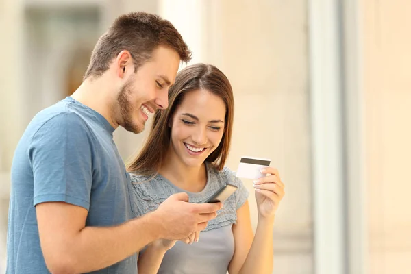 Casal pagando on-line com cartão credirt na rua — Fotografia de Stock