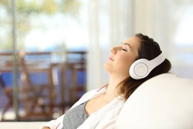 Müzik bir kanepede rahatlatıcı kadın