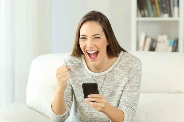 Glada kvinna håller telefonen tittar på dig — Stockfoto