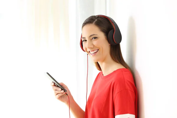 Szczęśliwa dziewczyna słuchanie muzyki na Ciebie patrzy — Zdjęcie stockowe