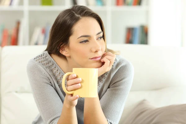 Pensive homeowner looking at side at home — Stock Photo, Image