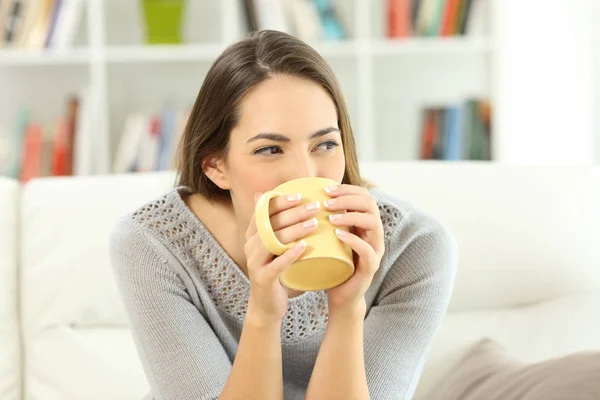 Mulher bebendo café olhando para o lado em casa — Fotografia de Stock