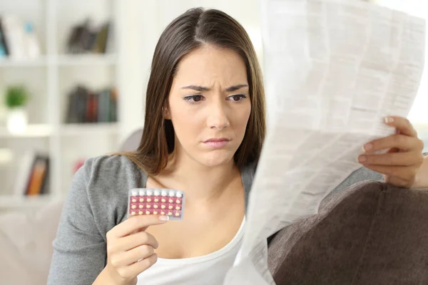 Mujer preocupada leyendo píldoras anticonceptivas folleto —  Fotos de Stock