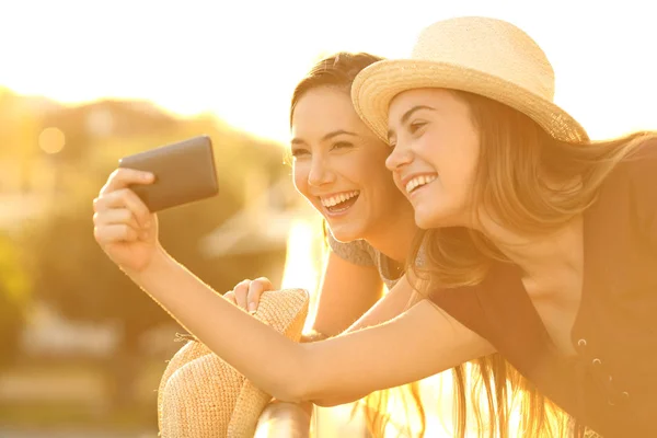Two tourist friends taking selfies in hotel balcony — Stock Photo, Image