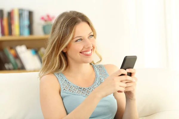 Menina sonhando e segurando um telefone inteligente — Fotografia de Stock