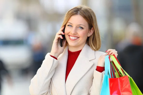 Happy shopper calling on phone and looking at you — Stock Photo, Image