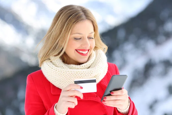 Femme payant avec carte de crédit et téléphone en hiver — Photo