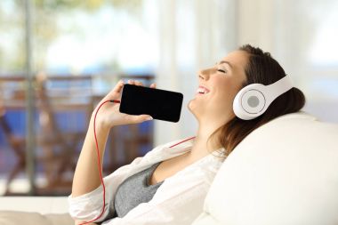 Kız müzik dinleme ve gösteren telefon ekran kapalı