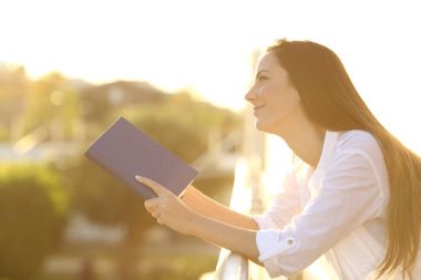 Günbatımında bir kitap okuma hayal kadın