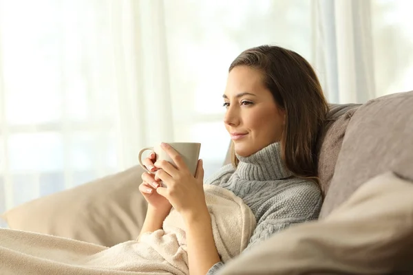 Inquilino descansando sosteniendo café en un sofá — Foto de Stock