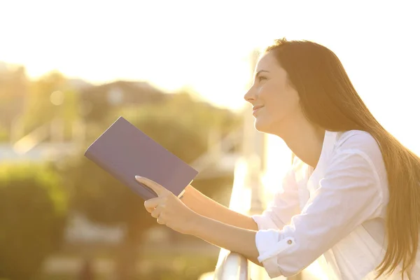 Mulher sonhando ler um livro ao pôr do sol — Fotografia de Stock