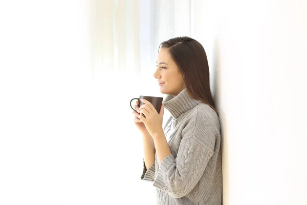 Mulher olhando para longe segurando uma caneca de café — Fotografia de Stock