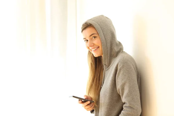 Smiley Teenager hält Telefon in der Hand und schaut dich an — Stockfoto