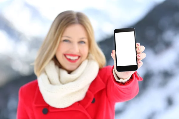 Mädchen zeigt leeren Handybildschirm in einem schneebedeckten Berg — Stockfoto