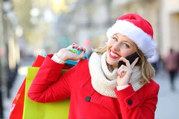 Boldog vásárlók, a hívó telefonján a karácsonyi bevásárló szatyrok — Stock Fotó