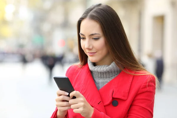 Femme sérieuse utilisant un téléphone intelligent en hiver — Photo