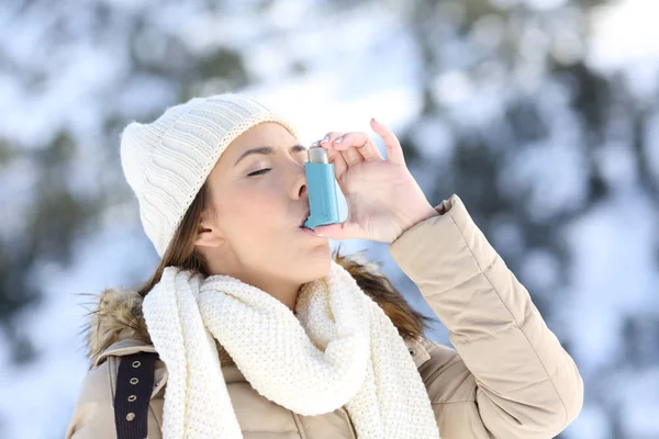 Женщина, использующая ингалятор астмы в холодную зиму — стоковое фото