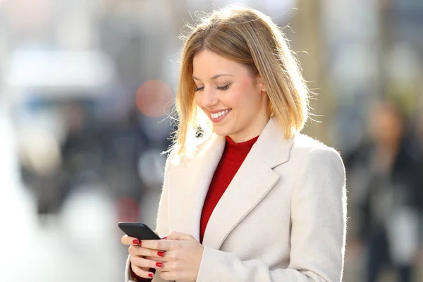 Lady skrift i en smart telefon på gatan — Stockfoto