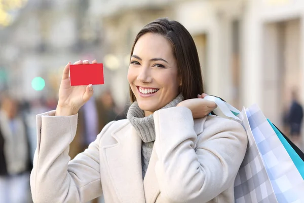 Cliente mostrando cartão de crédito na rua no inverno — Fotografia de Stock