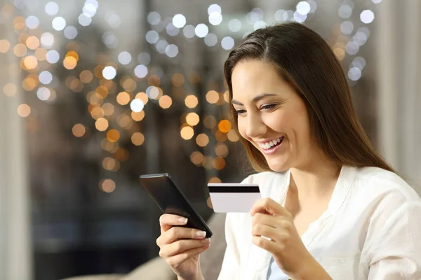 Chica compra en línea con tarjeta de crédito y teléfono en casa —  Fotos de Stock