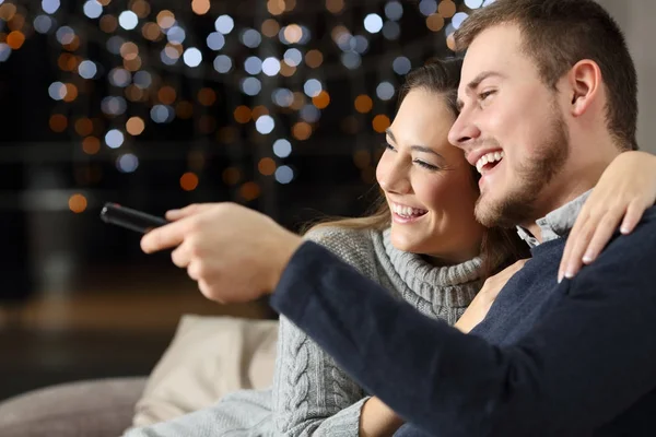 Funny couple watching tv at home in winter