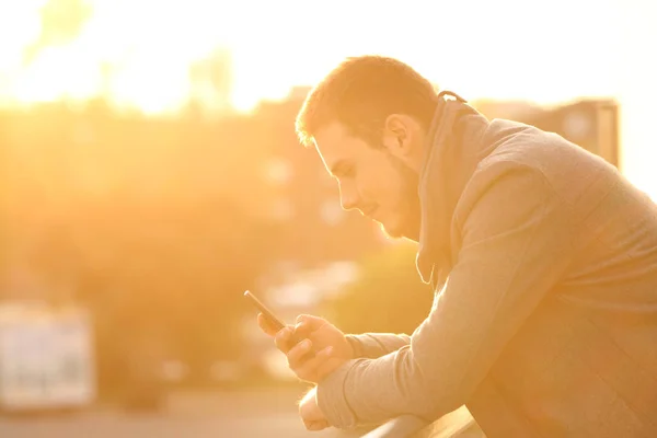 Kışın bir akıllı telefon kullanan bir adam profili — Stok fotoğraf