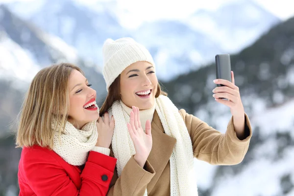 Two tourists having a video call in winter holidays — Stock Photo, Image