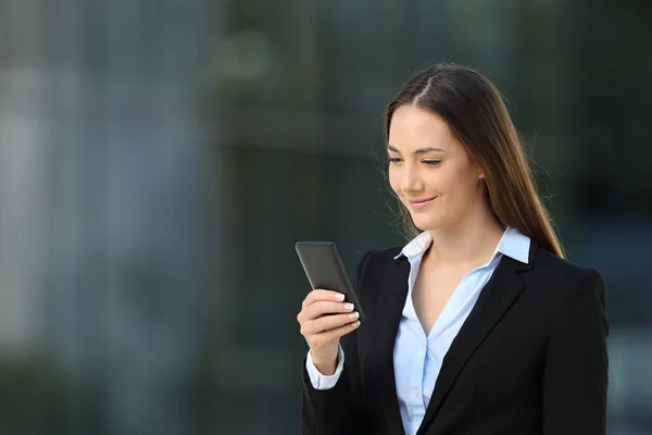 Executive checking a smart phone on the street — Stock Photo, Image