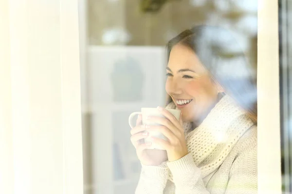 Senhora olhando através de uma janela no inverno — Fotografia de Stock