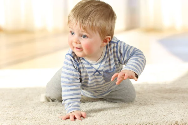 Bebé distraído arrastrándose en una alfombra en casa — Foto de Stock