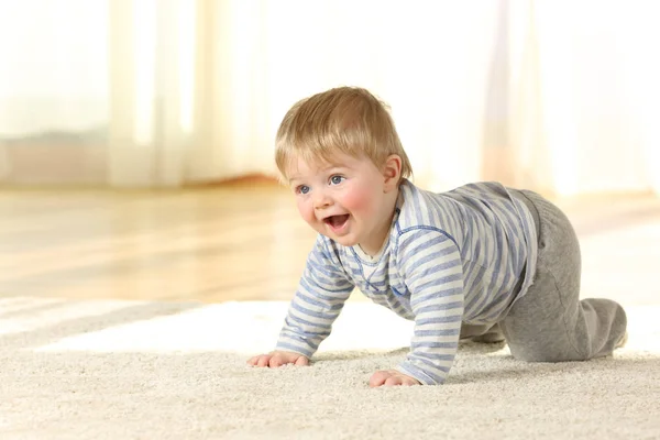 Bambino felice che striscia e ride su un tappeto — Foto Stock