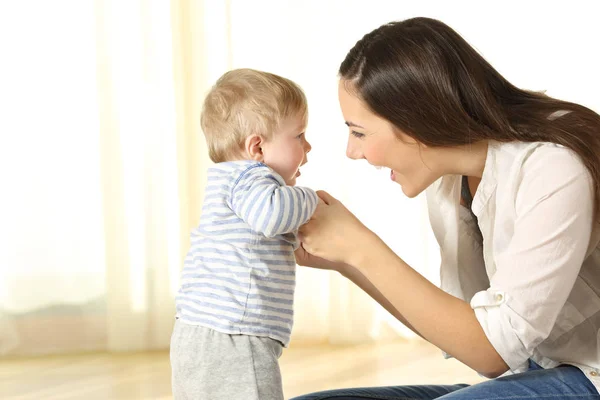 Mother helping her baby son in his first steps — Stock Photo, Image