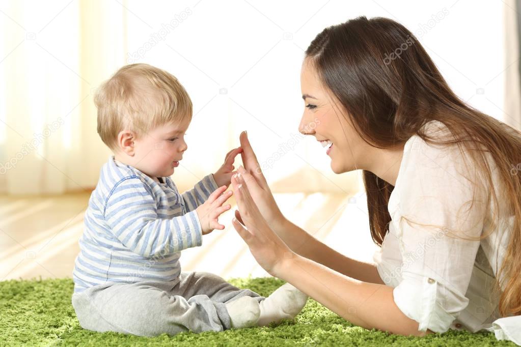 Mother playing with her baby on a carpet