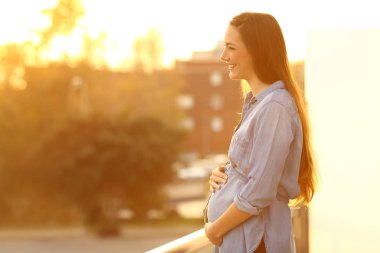 Hamile kadın uzak bir balkonda arıyor