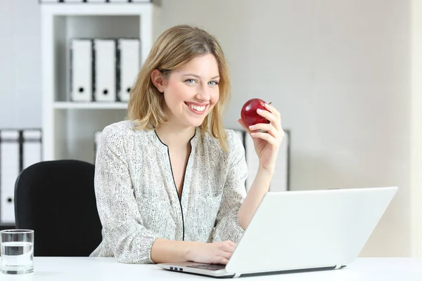 Femme d'affaires tenant une pomme vous regardant au bureau — Photo