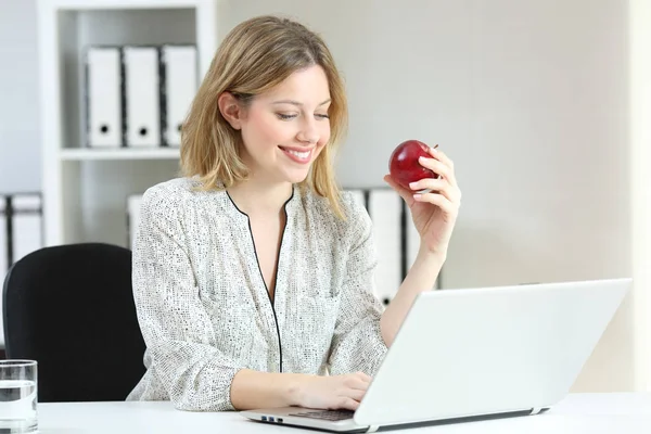 Femme d'affaires travaillant tenant une pomme au bureau — Photo