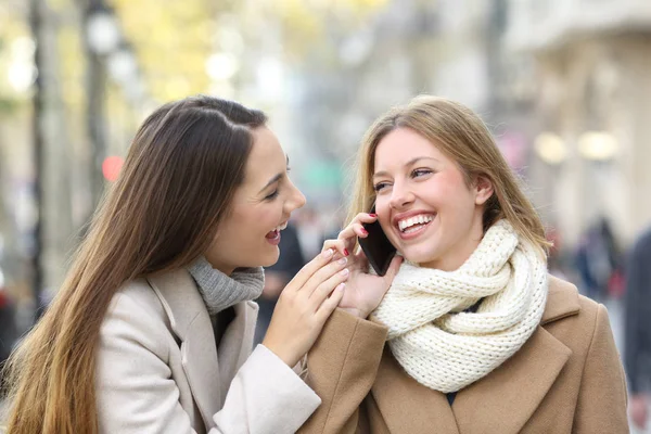 Vänner prata telefon på gatan vintertid — Stockfoto